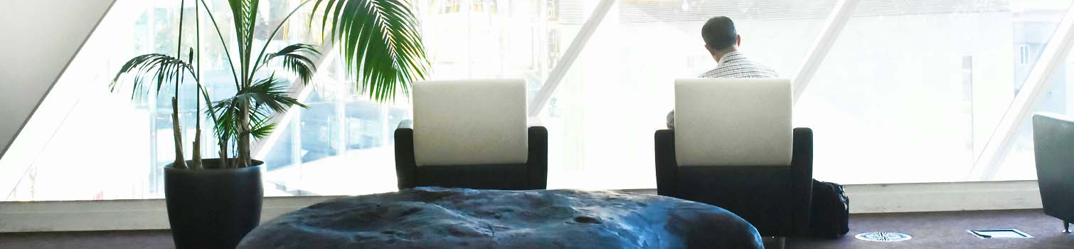 Bright office waiting area with a person seated by a window